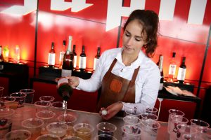 Horeca medewerker schenkt drankjes uit achter de bar