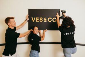 Medewerkers monteren het bord met ons logo